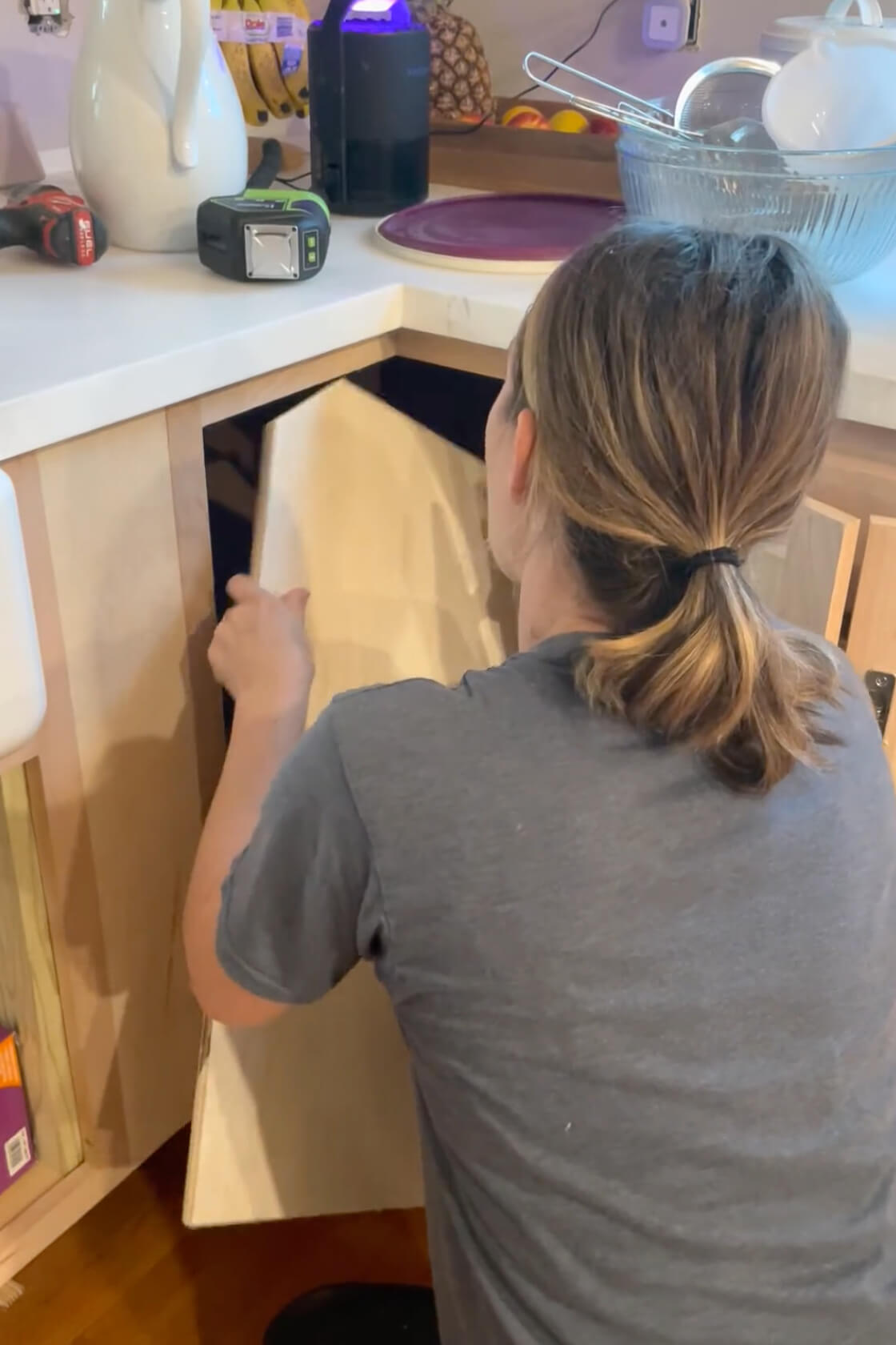 Fitting a shelf into a DIY kitchen cabinet.
